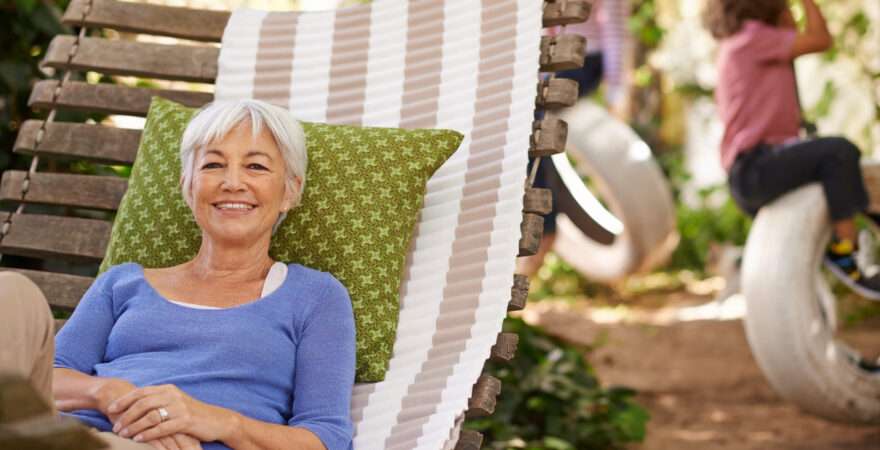 Seniorka relaxující v houpací síti na zahradě