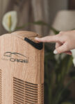 Purificatore d'aria Ionic-CARE in ambienti chiusi, dettaglio accensione čističky, finitura legno rovere